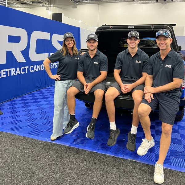 The RCS family at their show stand, sitting on the tailgate of a ute with the RCS canopy