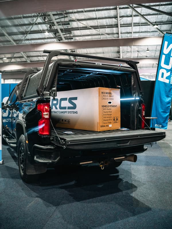 The RCS canopy box standing in the open tub of a Silverado 2500 at a 4x4 show