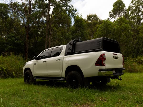 A white Toyota HiLux with the RCS canopy closed in a paddock