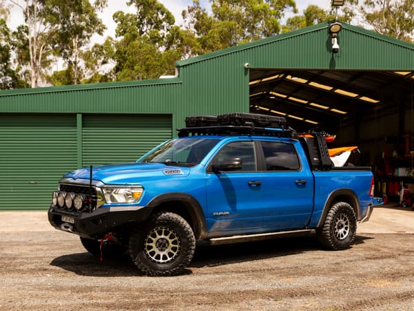 A RAM 1500 outside a shed with dirt bikes in the open tub