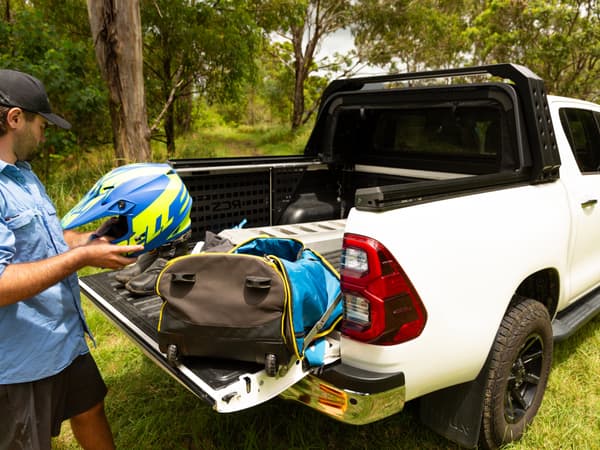 Gear being loaded into the open tub of a HiLux