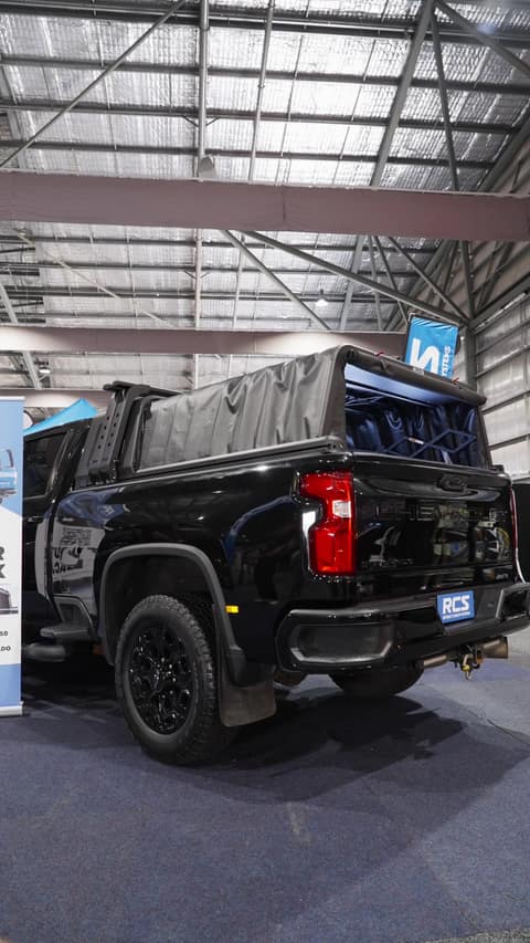 The RCS canopy folding back into its headboard on a black Silverado 2500 at the 4x4 show